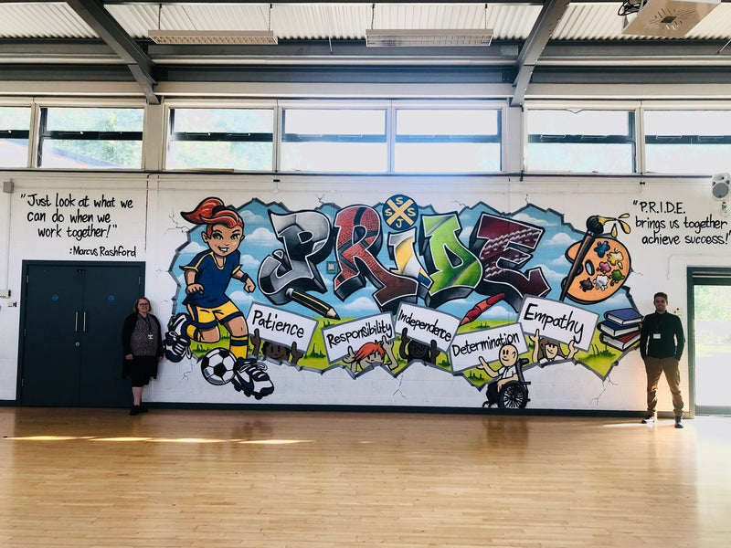 Mural with cartoon characters and text on a wall in a school setting
