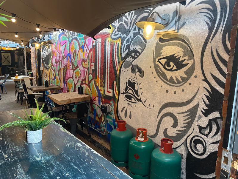 Colorful mural on a wall with tables and chairs in a restaurant setting