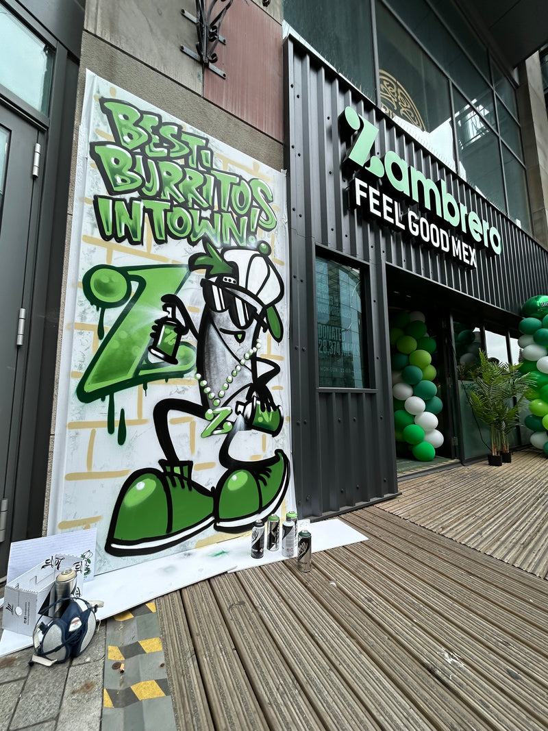 Green and white mural on a building facade with text and graphics.